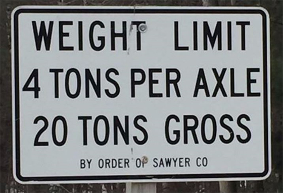 A road sign that reads: weight limit 4 tons per axle 20 tons gross