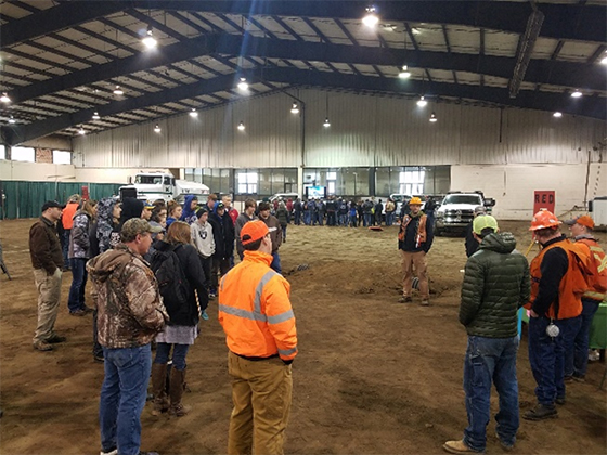 A crowd of students listening to an instructor.