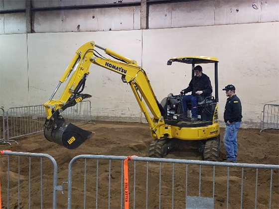 A student practicing on a back hoe