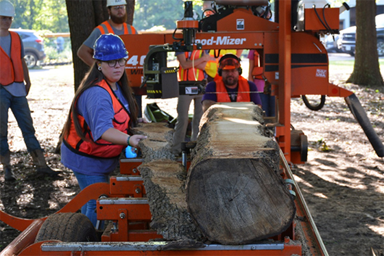 Students learning on a portable saw mill