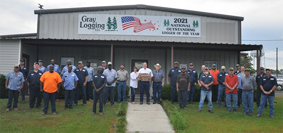 Jerry Gray (center with award plaque) poses with his wife, Ginger, and father, W.C., along with the rest of the Gray Logging, LLC team.