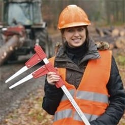 Female forest sector worker with hard hat and orange safety vest
