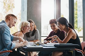 group of students working together at a desk, table